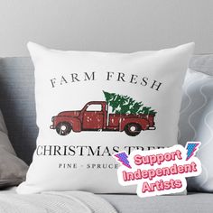 a red truck with a christmas tree on the back is sitting in front of a pillow