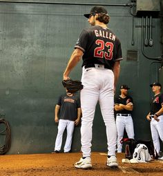 a baseball player standing in the outfield with his glove on and other players behind him