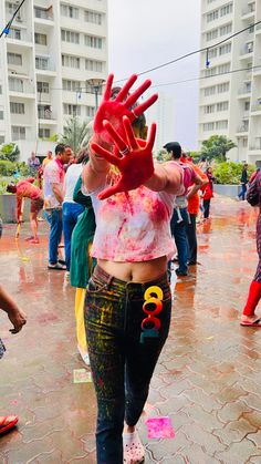 a woman with painted hands and numbers on her body is walking in the middle of a crowd