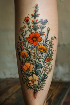 a woman's leg with flowers and leaves painted on the side by tattoo artist