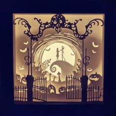 a paper cut out of a gate with halloween decorations on it and bats in the background