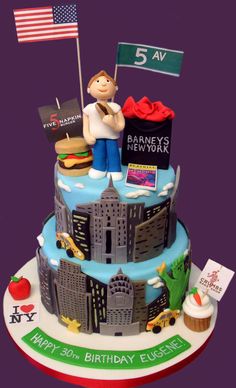 a three tiered cake decorated with an american flag and cityscape on top