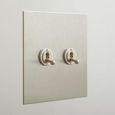 two light switches on a white wall