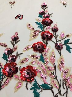 red and pink flowers on white fabric with butterflies in the sky behind them, as if they were made out of sequins