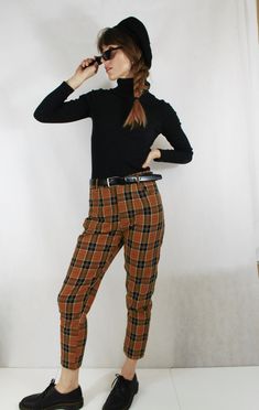 Fully lined check tartan patterned tapered Mom jean style chino/Capri pants in navy and chestnut brown colourway. Other colours available in our shop (see final photo). - Flattering high rise at the waist and narrow at the ankle - Two pockets - Belt loops - Fully lined Outer material is 100% cotton and looks great paired with Doc Martens and a navy ribbed turtle neck. Sizing: Sizes UK 6, 8, 10, 12, 14, 16, 18, 20 & 22 available, please see the last photo for sizing chart. Condition: New. Pos Vintage Ankle Pants For Fall, Retro Style Winter Workwear Pants, Retro Plaid Pants For Fall, Plaid Tapered Leg Pants For Fall, Plaid Tapered Leg Bottoms For Fall, Tapered Leg Plaid Bottoms For Fall, Vintage Plaid Pants For Fall, Vintage Plaid Bottoms For Work, Turtle Neck Outfits