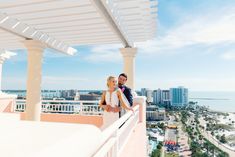 a bride and groom standing on the balcony of their hotel room overlooking the beach in miami