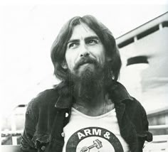 black and white photograph of a man with long hair wearing an army & hammer t - shirt