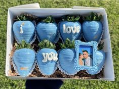 a box filled with blue strawberries covered in paper