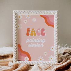 a frame with the words face painting station on it next to some yarn and flowers