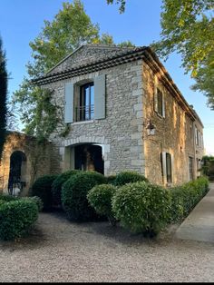 an old stone house surrounded by trees and bushes