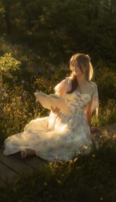 a woman in a white dress sitting on a wooden bench