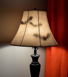 a lamp that is sitting on a table next to a red curtain and window sill