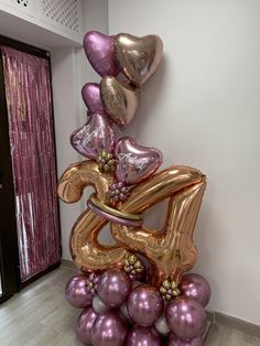 balloons are stacked on top of each other to spell out the number twenty five in gold and purple