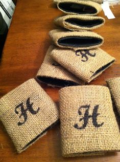 five burlap bags with monogrammed initials on them sitting on a table