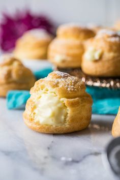 several pastries are sitting on a table with blue napkins and flowers in the background