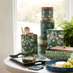 green and blue kitchen accessories on a table next to a window