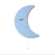 a blue moon clock with eyes hanging from it's side on a white wall