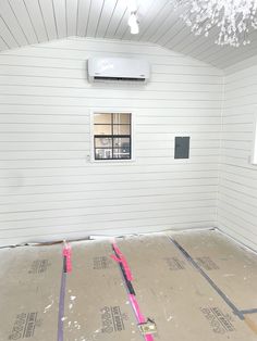 an unfinished room with white walls and wood flooring that is being installed on the wall