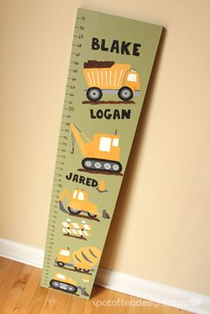 a wooden ruler with construction vehicles on it that says, bake logan jared