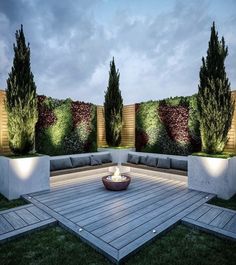 an outdoor seating area with fire pit and plants on the wall, surrounded by concrete planters