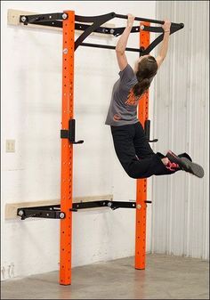 a man is hanging upside down on a pull up bar