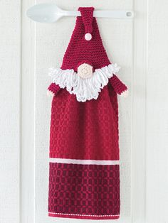 a crocheted towel hanging on a door hanger with a spoon in it