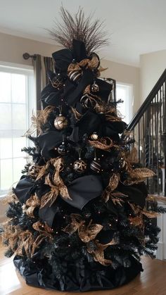 a black and gold christmas tree in a living room