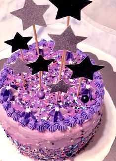 a cake with purple frosting and stars on top