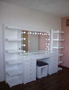 a white dressing table with lights on it