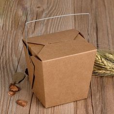 an open box sitting on top of a wooden table next to some ears of wheat