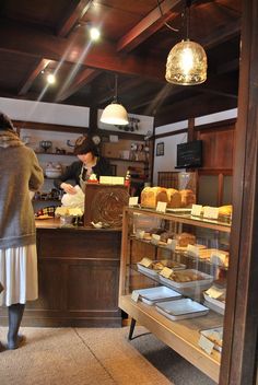 a woman standing in front of a counter filled with food