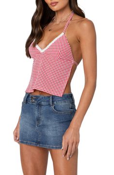 a woman wearing a red and white gingham crop top with an open back