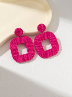 the pink beaded earrings are next to a white plate