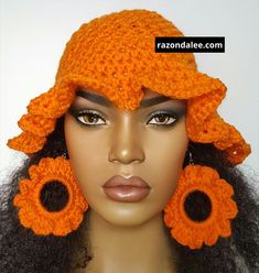 an orange crocheted hat and earring set on a mannequin head