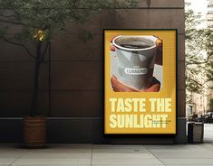 a poster on the side of a building that says taste the sunlight with a cup of coffee