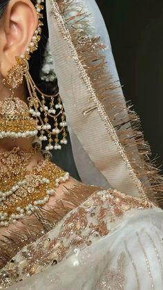 a close up view of a woman's face wearing gold jewelry and headpieces