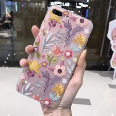 a person holding up a phone case with flowers on it