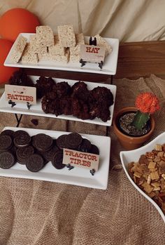 desserts and snacks are displayed on trays on a bed