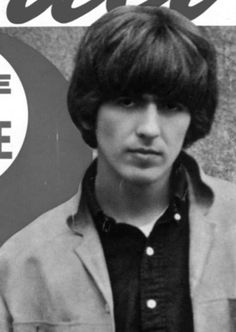 an old photo of a young man in front of a sign