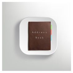 the address book is sitting on top of a white plate with a brown leather cover