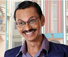 a man with glasses and a mustache smiling