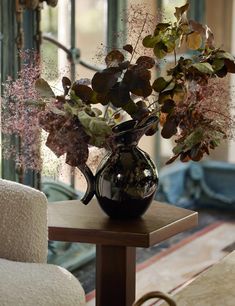 a vase filled with flowers sitting on top of a wooden table