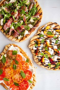 three pizzas with different toppings on them sitting on a white counter top next to each other