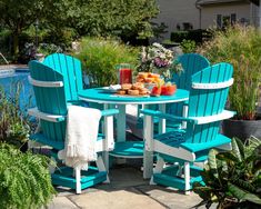 an outdoor table and chairs with food on it next to a swimming pool in the background