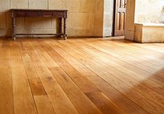 an empty room with wooden floors and a bench