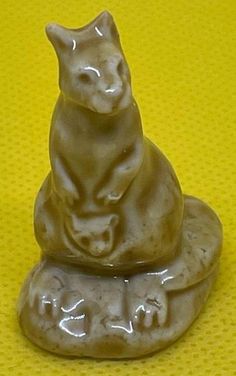 a cat figurine sitting on top of a rock