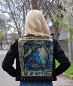 a woman wearing a jacket with an image of a witch on it