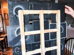 a person standing next to a window frame in the process of being constructed with plywood