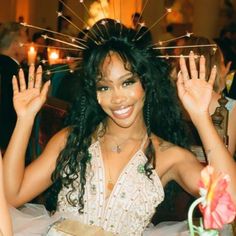 a woman sitting at a table with her hands in the air