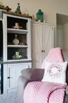 a living room filled with furniture and a pink blanket on top of a gray chair